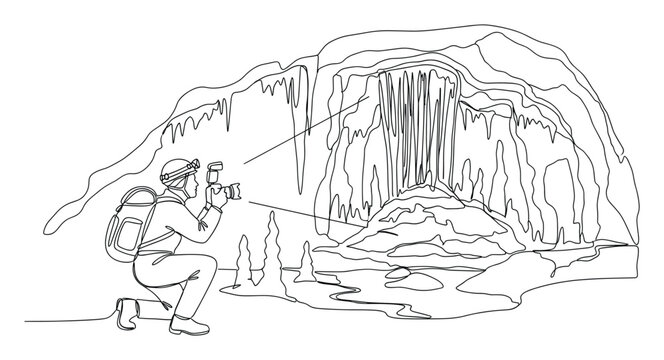 Adventurous speleologist photographing intricate geological cave structures with camera and light for travel and exploration media