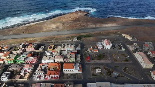 Aerial view of the coastal town of Ponta do Sol in Santo Antao, Cape Verde. Drone shot of the colorful urban settlement, colonial buildings, and the nearby ocean shore at sunset