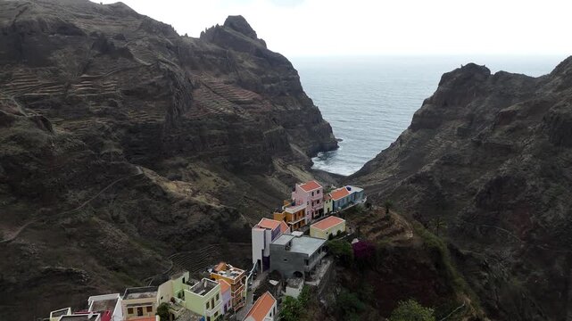 Aerial view of Fontainhas village perched on cliffs in Santo Antao, Cape Verde. Iconic colorful houses in a deep volcanic valley opening to the Atlantic Ocean under a dramatic sky