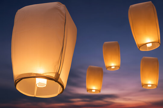 Sky lanterns flying in the air at sunset or sunrise