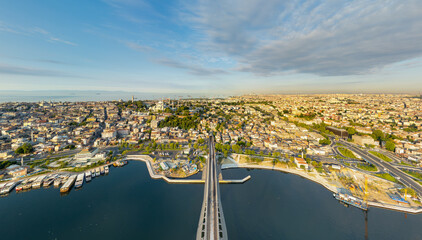 Fototapeta premium Istanbul, Turkey. Halic Metro Bridge going into tunnel under Fatih district, aerial view of metro line and panoramic cityscape at sunrise. Aerial view
