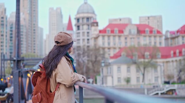 Happy Woman Traveler relaxes and enjoys the view of a Tianjin City with European-Style Architecture