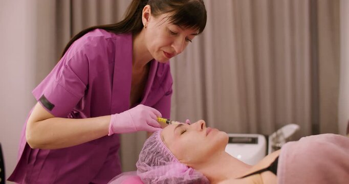 Beauty care. Aesthetic cosmetology. Female professional cosmetologist making botulinum toxin injection procedure for face skin treatment.
