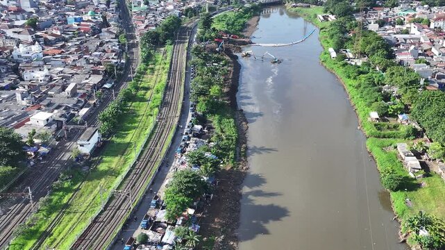 Aerial view The blue and yellow excavator is working to dig and clean the river from mud and rubbish, removing it to the edge of the river middle city 