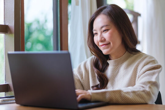 Portrait of a woman using and working on laptop computer at home