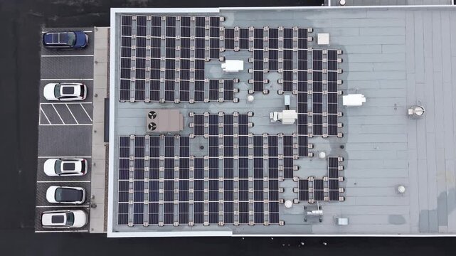 Top View of a large rooftop solar power plant on an auto dealership in Halifax, Nova Scotia, Canada. Grid-tied solar panels, inverters and mounting racks for distributed energy generation 4K.