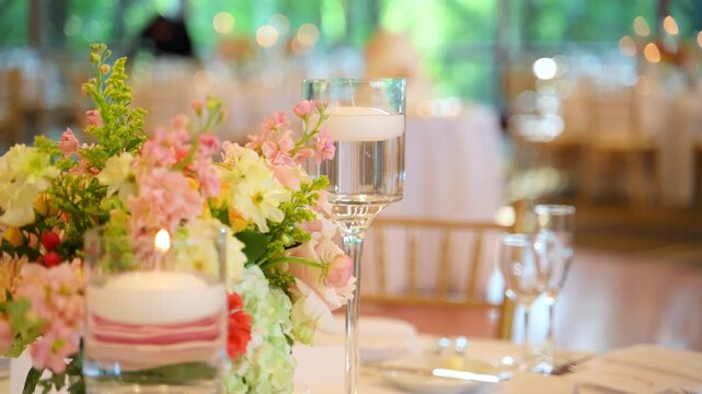 Lighting candle at elegant wedding table setup. Close up of hand lighting candle near floral centerpiece and table decor.