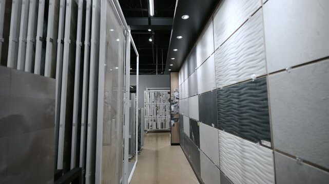Element of Modern tile showroom interior with large size ceramic and porcelain slabs displayed in vertical racks. Dolly tracking camera move.