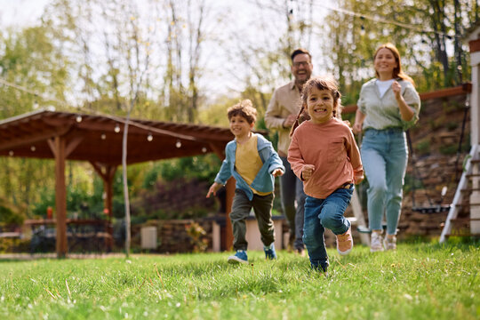 Carefree girl and her family having fun while running in spring day outdoors.