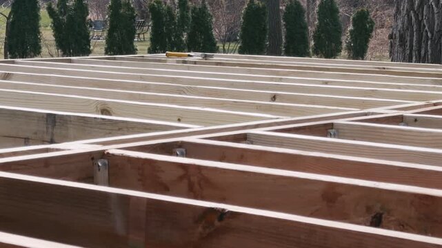 Wooden floor joints installed in parallel during construction of the deck or house home frame. Structural framing stage. Move camera view