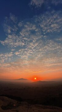 Beautiful orange sun rising behind the misty la malinche volcano in mexico, seen from a high peak