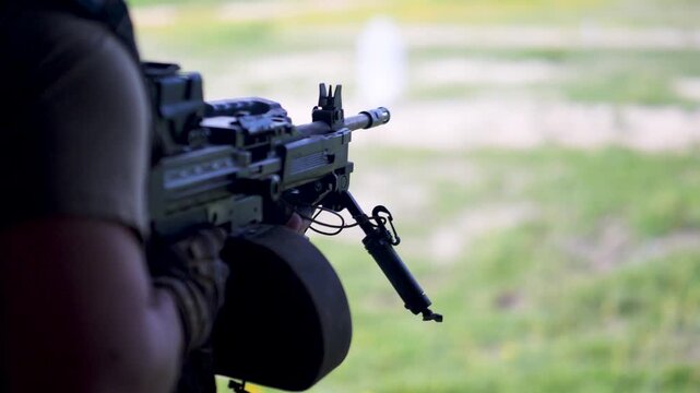 Israeli army soldier fires machine gun with visible shell ejection outdoors