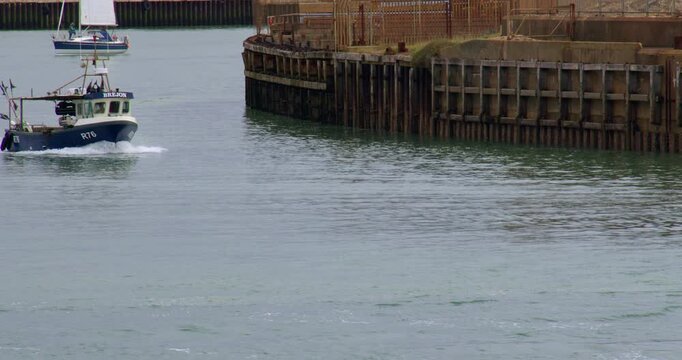 Wide shot of a fishing boat leaving Shoreham Harbour