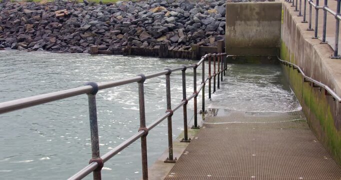 Incoming tide flooding the ramp to the beach at Shoreham harbour