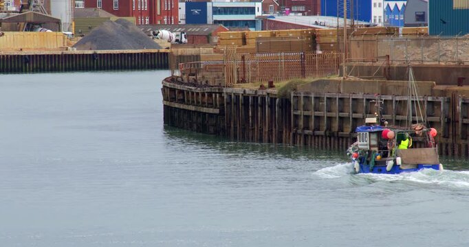 Wide shot of a fishing boat entering Shoreham Harbour