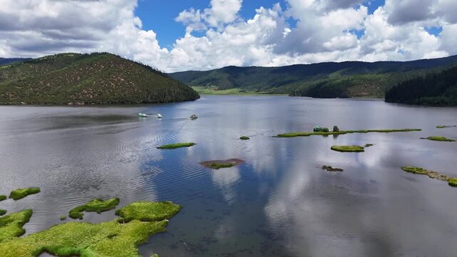 Bita Lake peaceful surface reflecting clouds, Potatso National Park, Yunnan, China