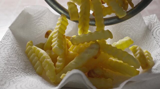 Close up of crinkle fries served on absorbent paper