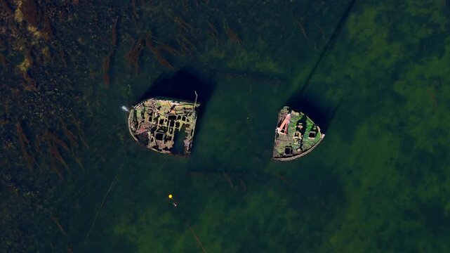Overhead drone shot of the SS Kaffir, a Clyde Puffer shipwreck split in two off the coast of Ayr, Scotland. Clear view of the rusted metal hull and underwater debris