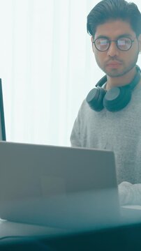 Vertical Screen : Young adult Asia male freelance eyeglasses typing write prompt AI bot app smart program nomad, video game, terminal with coding, user interface, big data center on desktop computer.