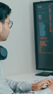 Vertical Screen : Young adult Asia male freelance eyeglasses typing write prompt AI bot app smart program nomad, video game, terminal with coding, user interface, big data center on desktop computer.