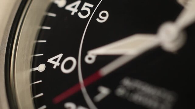 Macro close up of an automatic mechanical field watch with moving arms
