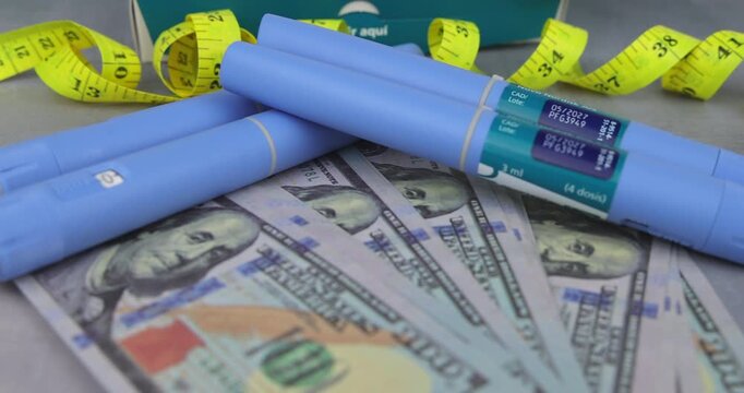 Detailed pan over glp-1 injector pens on dollar bills for representing the high price of obesity management and skin fold results.