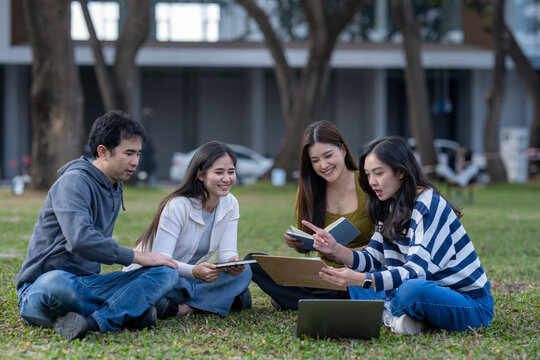 Diverse students studying together on university campus lawn