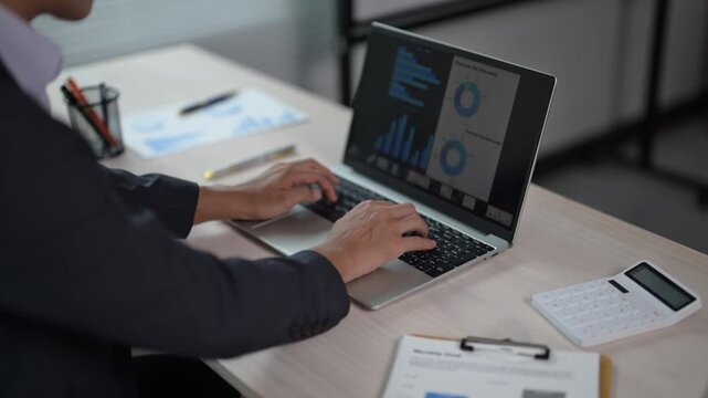 Business Professional Analyzing Data on Laptop at Modern Workspace