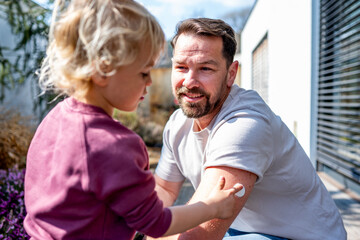 Fototapeta premium Diabetic dad showign his young son CGM sensor on his arm.