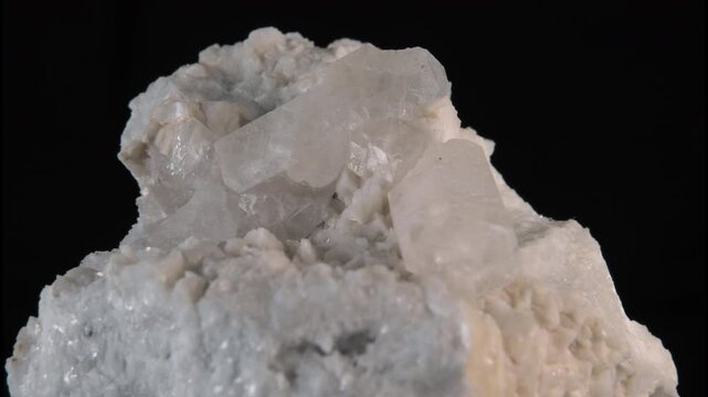 A sample of white quartz or milky quartz isolated on a black background, loop rotation