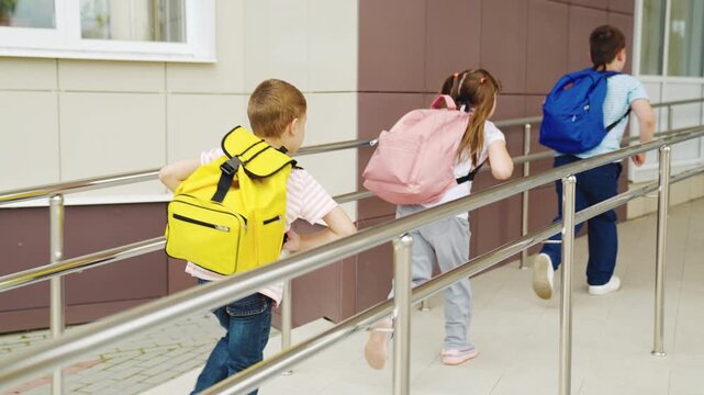 Children on their way to school, Kids walking with backpacks, First day of school excitement, Back to school moments, Young students together, School entry ramp scene, Friendship and education