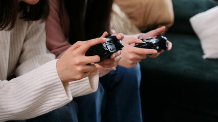 Fototapeta premium Two people are holding game controllers, actively engaged in playing a video game at home
