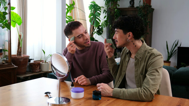 Young gay couple performing a skincare routine together at home