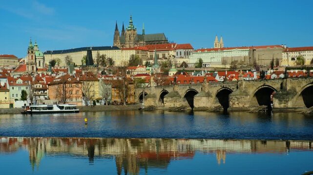 Experience the enchanting sights of Prague as the majestic castle overlooks the serene Vltava River. The reflections on the water showcase vibrant architecture and rich history.