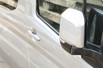 Fototapeta premium Detailed close up view of steady silver car exterior showing modern side mirror door handle and window reflection highlighting clean vehicle transportation design outside