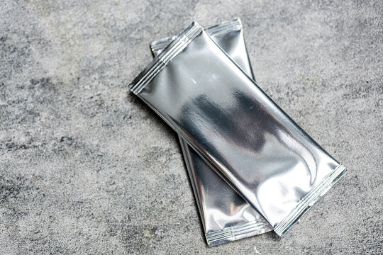 Blank trading card collectible game with shiny foil plastic booster pack mockup. Top view