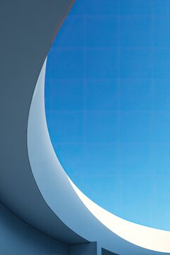 A striking architectural detail frames a vibrant blue sky, creating a captivating interplay of curves and geometric patterns.