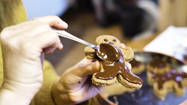 femme &eacute;talant du chocolat sur un bonhomme en pain d&rsquo;&eacute;pices gros plan p&acirc;tisserie de No&euml;l. High quality 4k footage