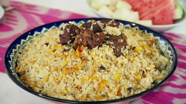 Close-Up of Traditional Uzbek Plov Pilaf with Meat, Rice, Carrots and Raisins on Serving Platter