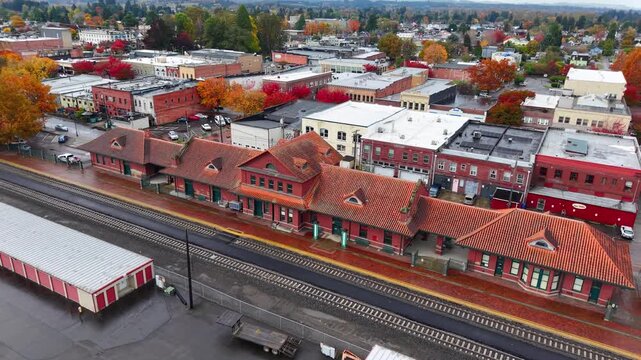Cinematic aerial drone view of historic downtown Train Station Centralia surrounded by vibrant fall foliage