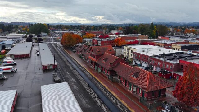 Cinematic aerial drone view of historic downtown Train Station Centralia surrounded by vibrant fall foliage