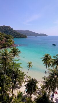 Discover the breathtaking beauty of Koh Kood, Thailand, where palm trees sway gently by the shoreline and crystal-clear waters invite relaxation. A perfect tropical getaway awaits.