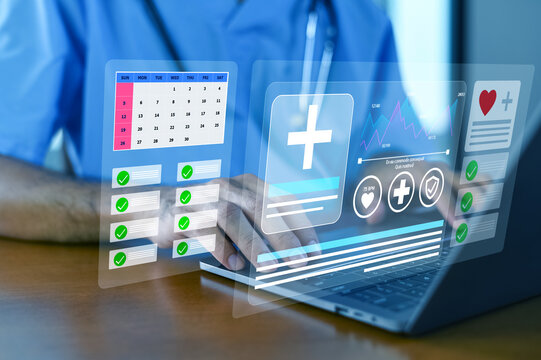 A healthcare professional interacts with advanced medical technology, showcasing digital interfaces and data management on a laptop for improved patient care.