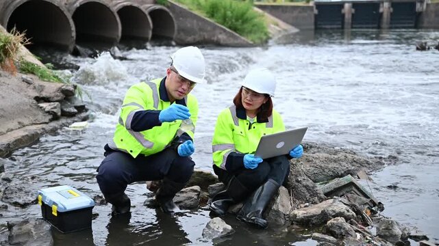 Environmental Engineers Collecting Water Samples from River for Quality Testing
