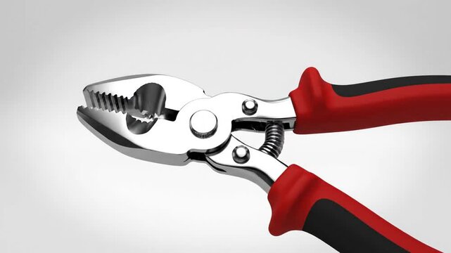 Close up of metal pliers with red handles against a simple background