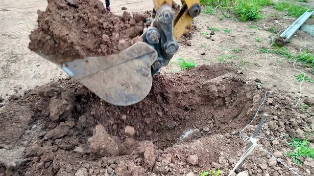 Ground slow motion shot of backhoe digging ground