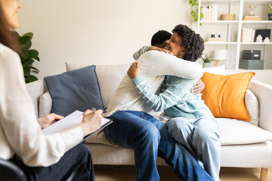 Happy couple embracing after successful therapy session with psychologist