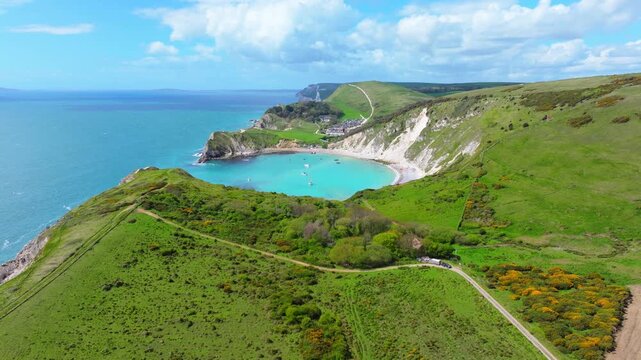 Ascending aerial shot of Lulworth cove and Dorset jurassic coastline on a sunny day	