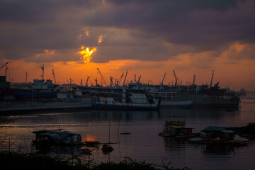 Naklejka premium Industrial Harbor at Sunset with Cranes and Ships