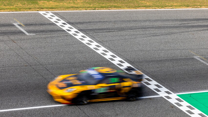 Fototapeta premium Motion blur, Race car racing on speed track, race car on road crossing start and finish line, Target business achieve and victory concept.